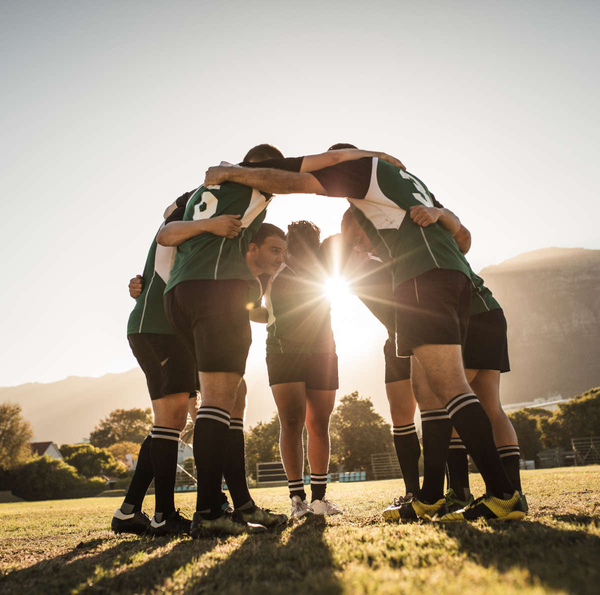 Rugby players huddling on sports field